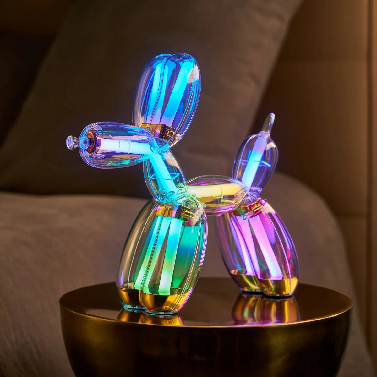 Illuminated Balloon Dog Lamp Chromatic in transparent gold polycarbonate, featuring integrated LED lighting and reflective sculptural form. Official Jeff Koons x Lexon collaboration, presented by Designooor Media and Academy. Written and edited by Hamed Mahzoon 
