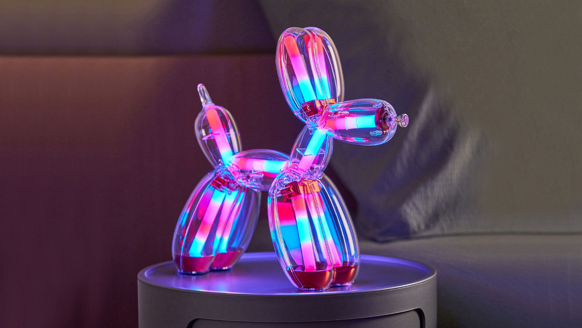 Illuminated Balloon Dog Lamp Chromatic in transparent gold polycarbonate, featuring integrated LED lighting and reflective sculptural form. Official Jeff Koons x Lexon collaboration, presented by Designooor Media and Academy. Written and edited by Hamed Mahzoon 