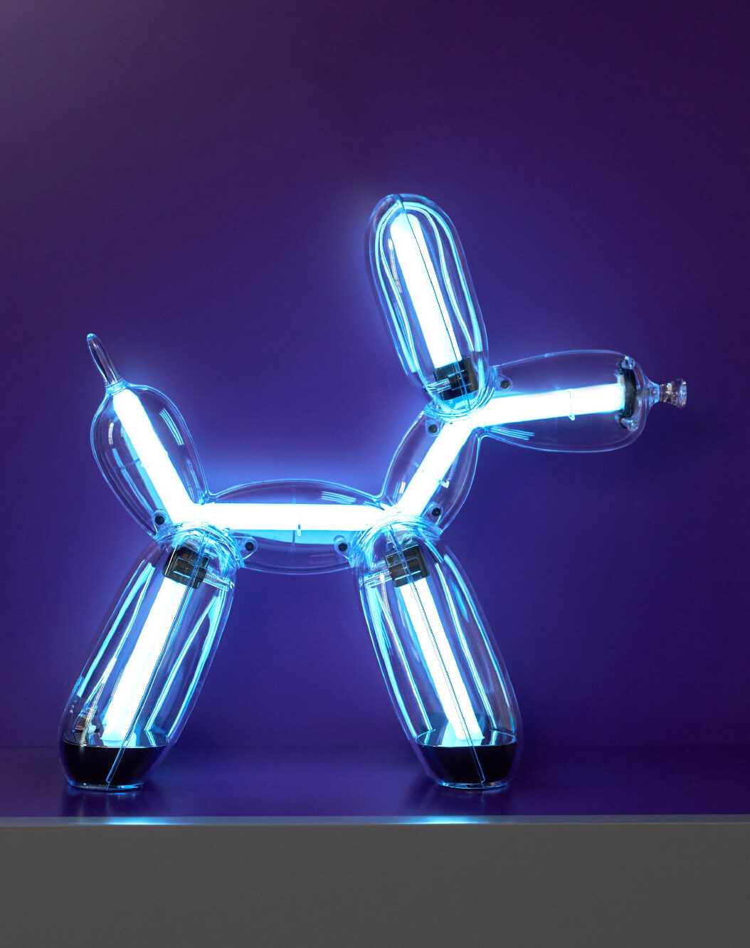 Illuminated Balloon Dog Lamp Chromatic in transparent gold polycarbonate, featuring integrated LED lighting and reflective sculptural form. Official Jeff Koons x Lexon collaboration, presented by Designooor Media and Academy. Written and edited by Hamed Mahzoon