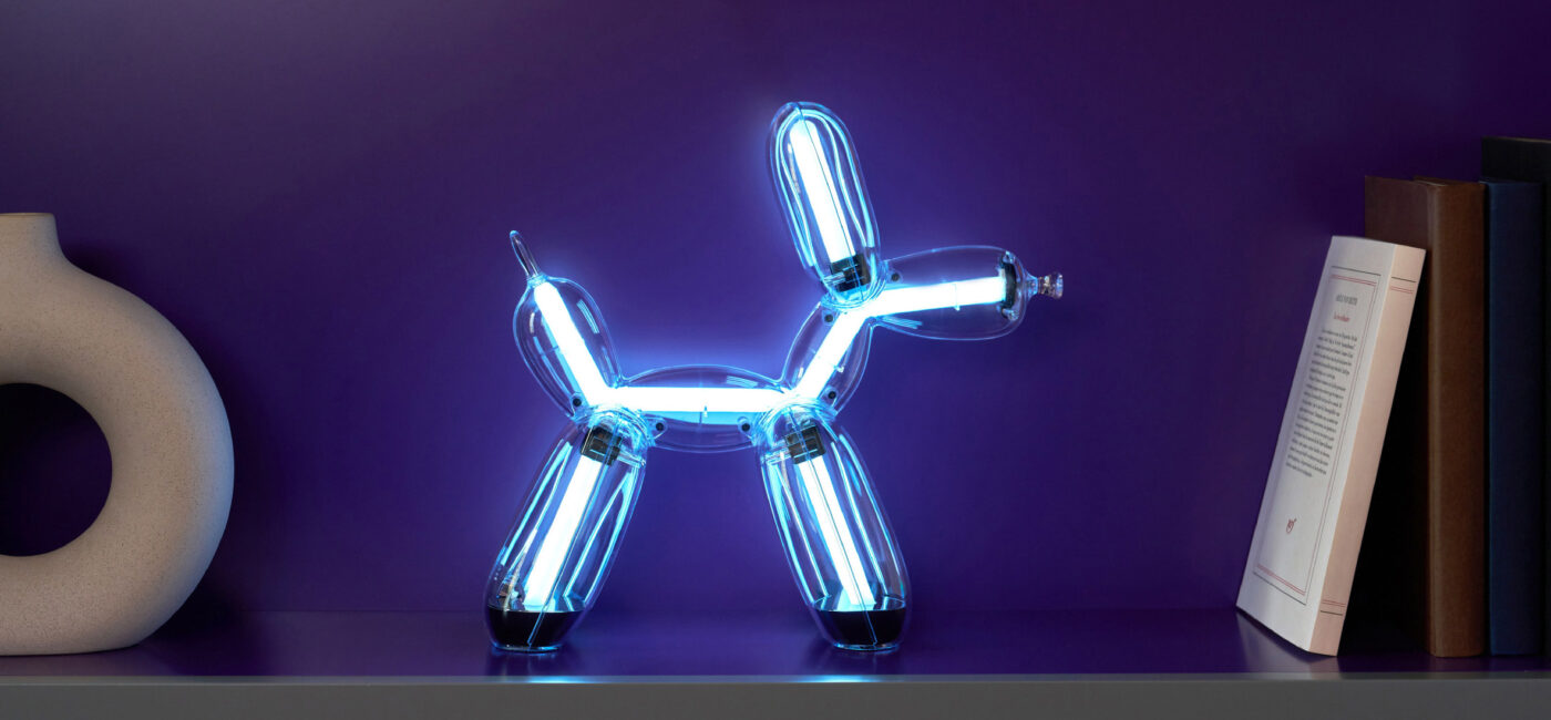 Illuminated Balloon Dog Lamp Chromatic in transparent gold polycarbonate, featuring integrated LED lighting and reflective sculptural form. Official Jeff Koons x Lexon collaboration, presented by Designooor Media and Academy. Written and edited by Hamed Mahzoon