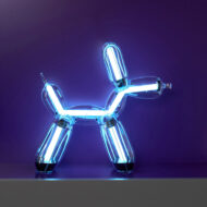 Illuminated Balloon Dog Lamp Chromatic in transparent gold polycarbonate, featuring integrated LED lighting and reflective sculptural form. Official Jeff Koons x Lexon collaboration, presented by Designooor Media and Academy. Written and edited by Hamed Mahzoon