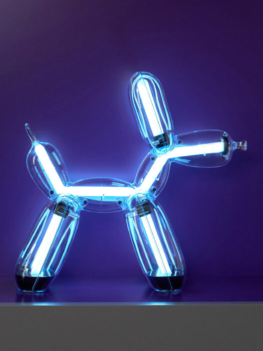 Illuminated Balloon Dog Lamp Chromatic in transparent gold polycarbonate, featuring integrated LED lighting and reflective sculptural form. Official Jeff Koons x Lexon collaboration, presented by Designooor Media and Academy. Written and edited by Hamed Mahzoon